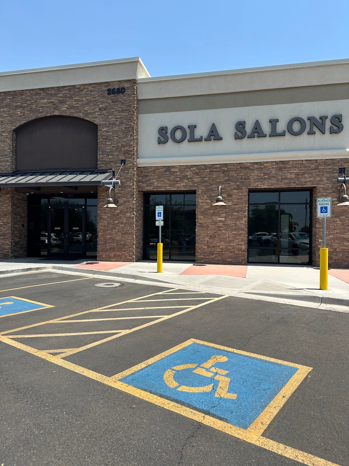 The front of the Sola Salons building at 2680 E Germann Rd, with accessible parking spaces