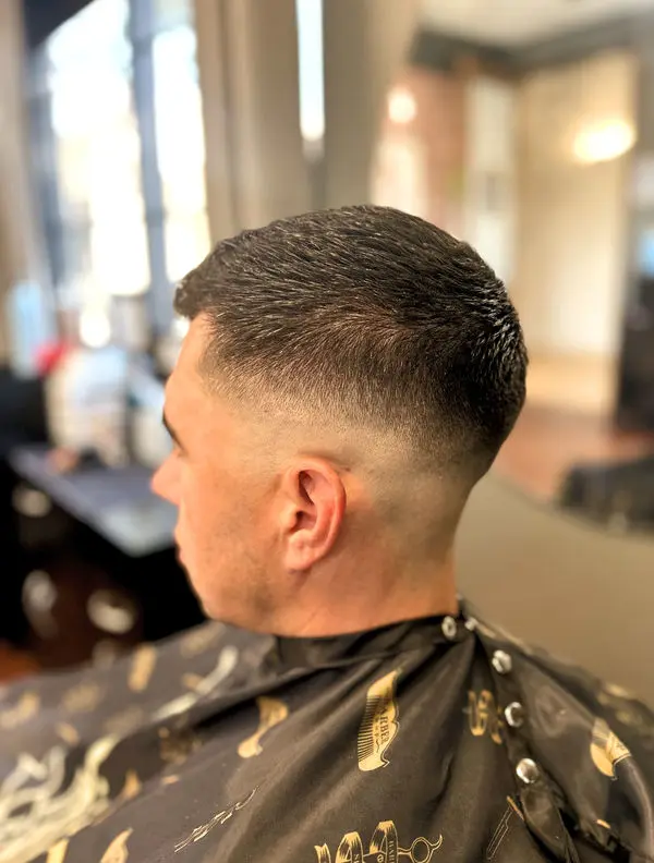 Side view of a low fade with a short textured top